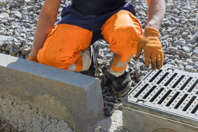 Drainagebau: Mitarbeiter von Staats GaLaBau bei der Verlegung von Entwässerungsanlagen auf Brunnenbeton